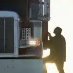 man climbing into truck