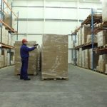 worker examining warehouse inventory