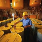 Worker Labeling Chemical Drums