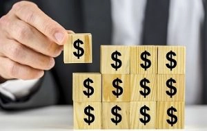 businessman assembling blocks with dollar signs